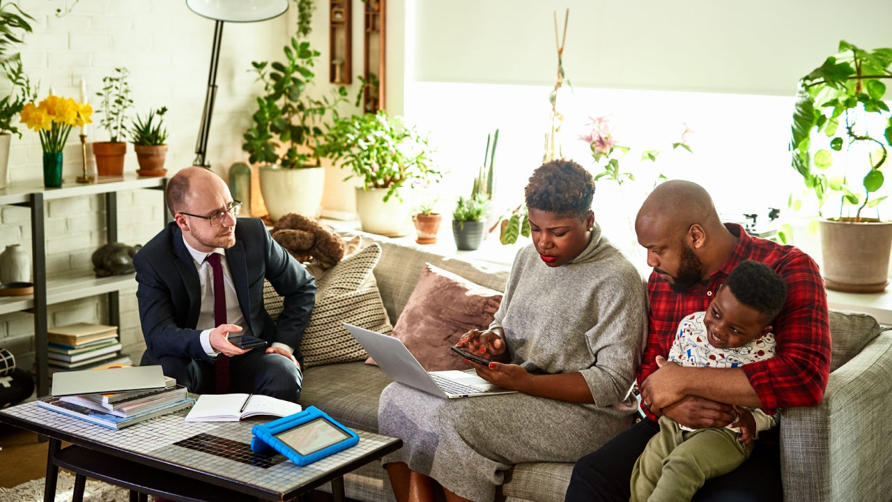 A couple and their child review their finances with a consultant.