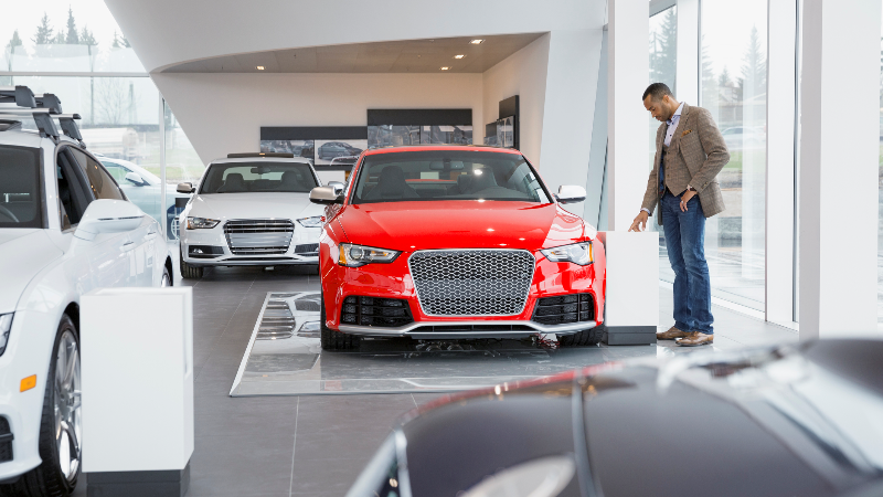 man looking at new car at dealership