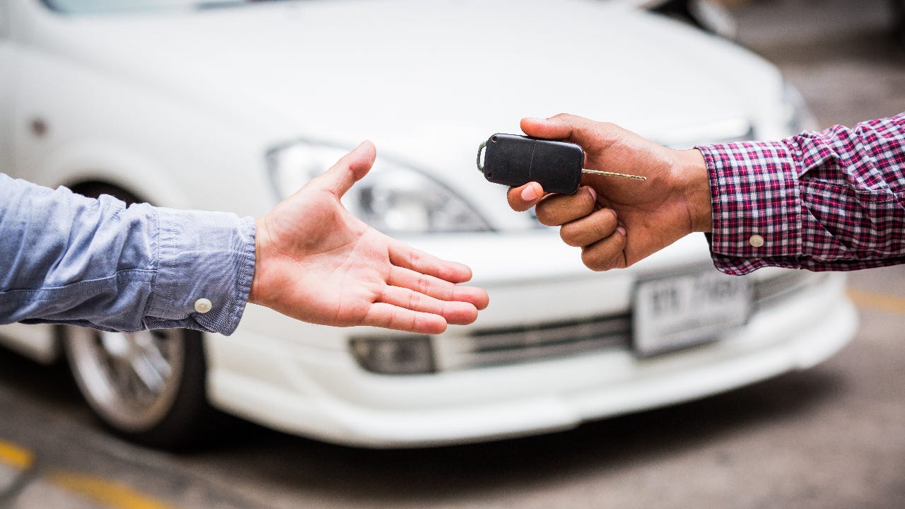 One person hands keys to another.