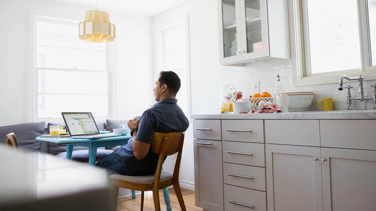 Consumer investigating unclaimed life insurance from his kitchen