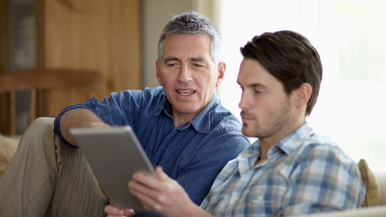 Father and son look at tablet