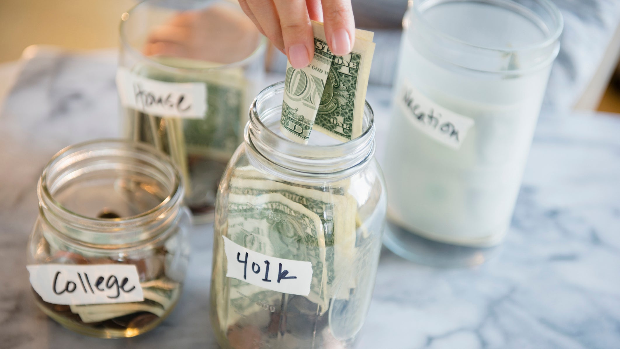 Mixed race woman saving money in jars