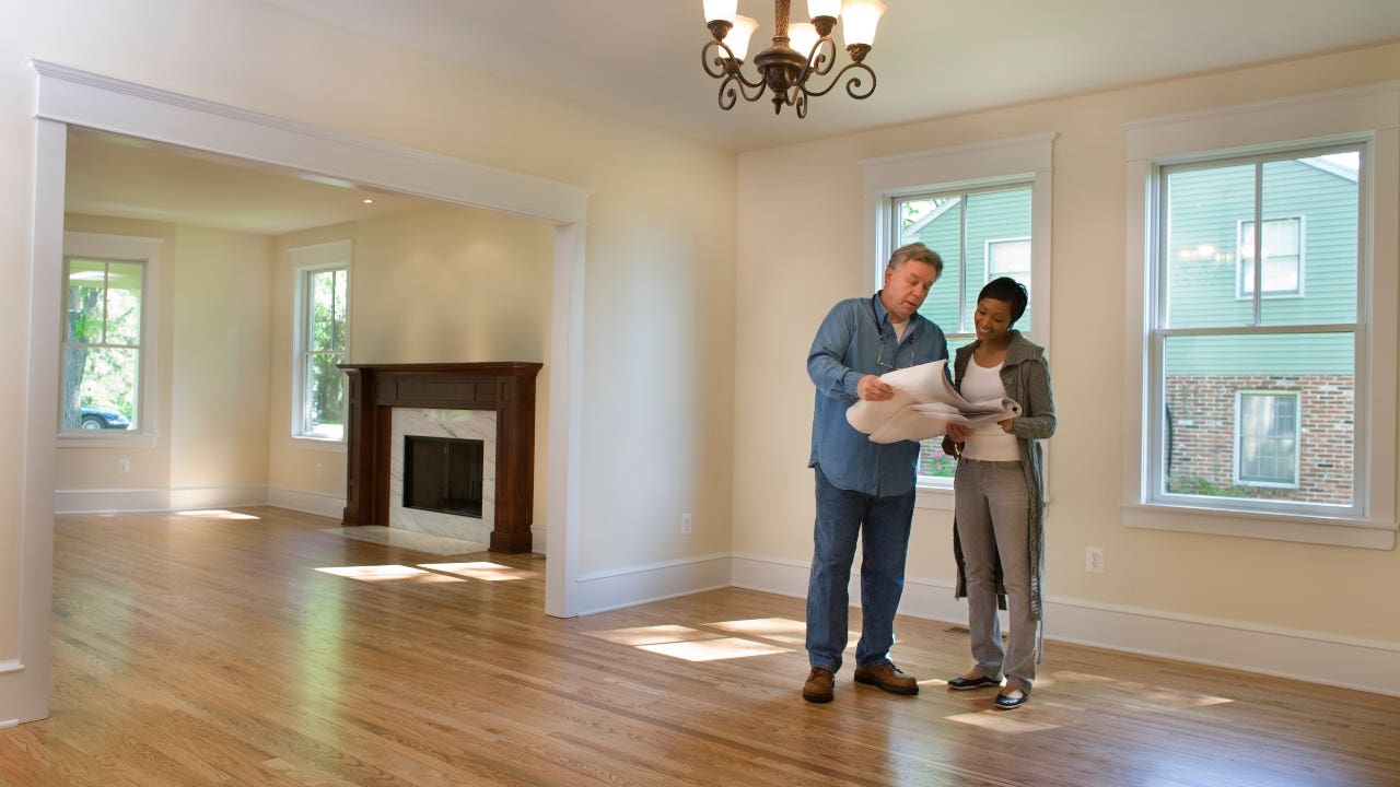 A contractor and a homeowner discuss construction plans.