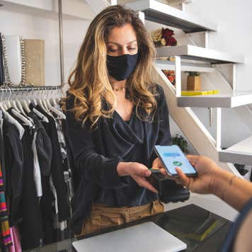 Woman at checkout counter taking credit card payment