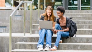 Two college students sit on steps outside