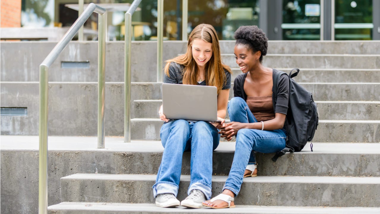 Two college students sit on steps outside