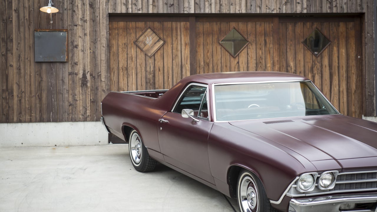 A vintage car parked in front of a house.