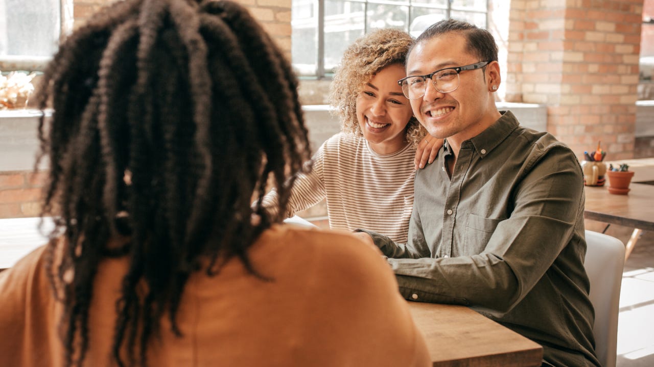 Asian interracial family discussing life insurance possibilities with agent