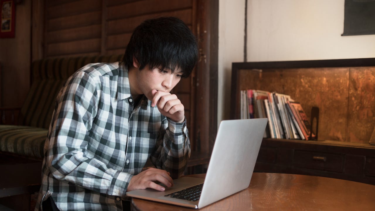 Man sat in a cafe using his computer