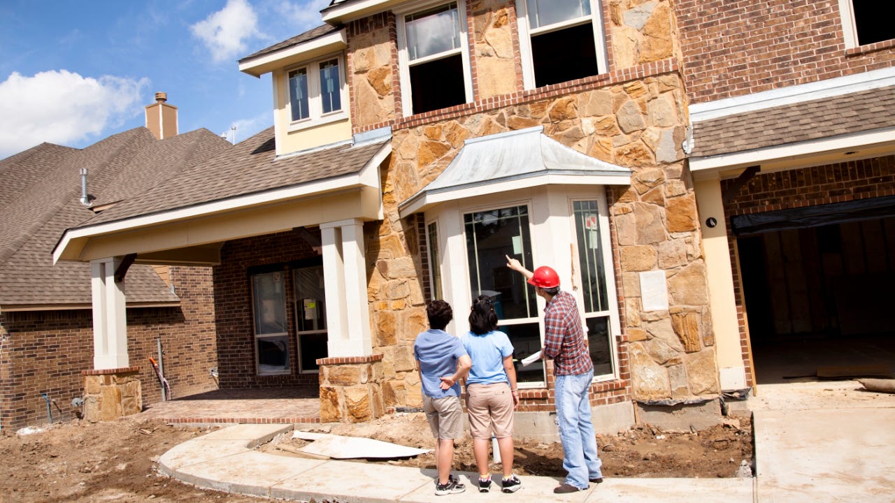 Builder meeting with woman and dauhter at new home under construction
