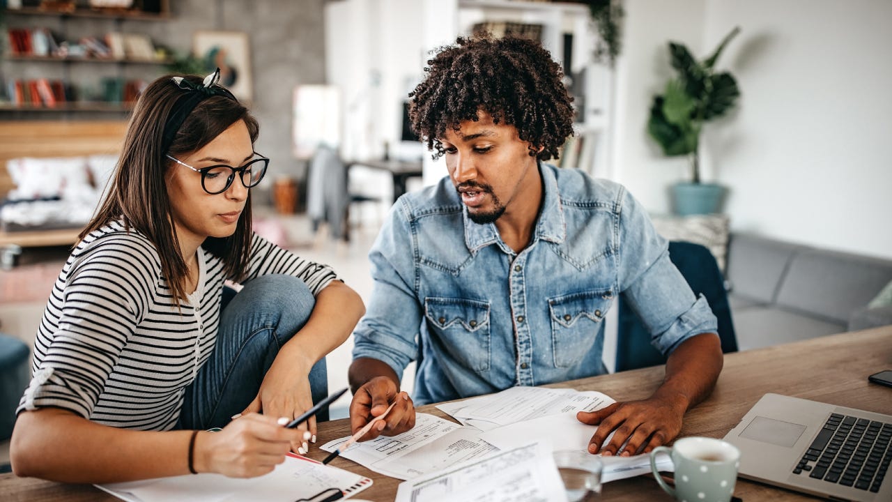 Multi-ethnic couple planning their home budget