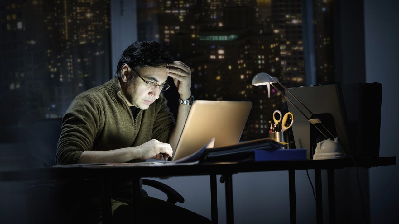 Mixed race businessman working late in office