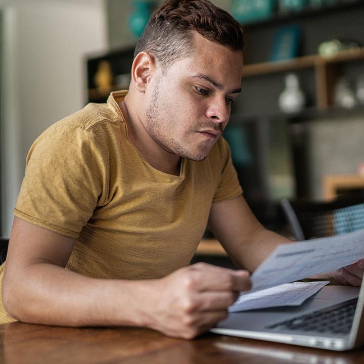 Young man with dwarfism doing home finances
