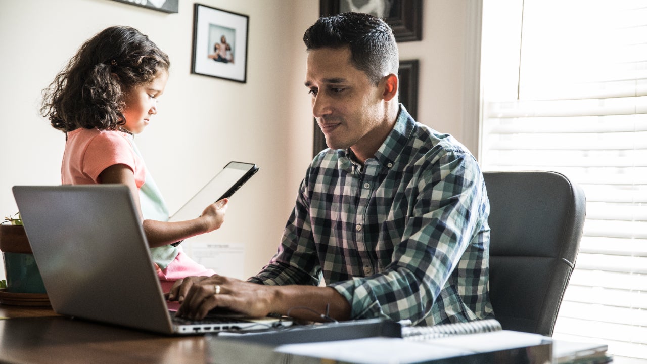 Person researching on computer next to child
