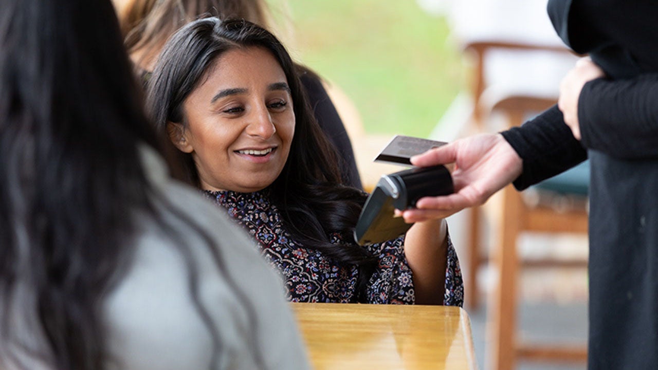 Woman making payment with credit card in cafe