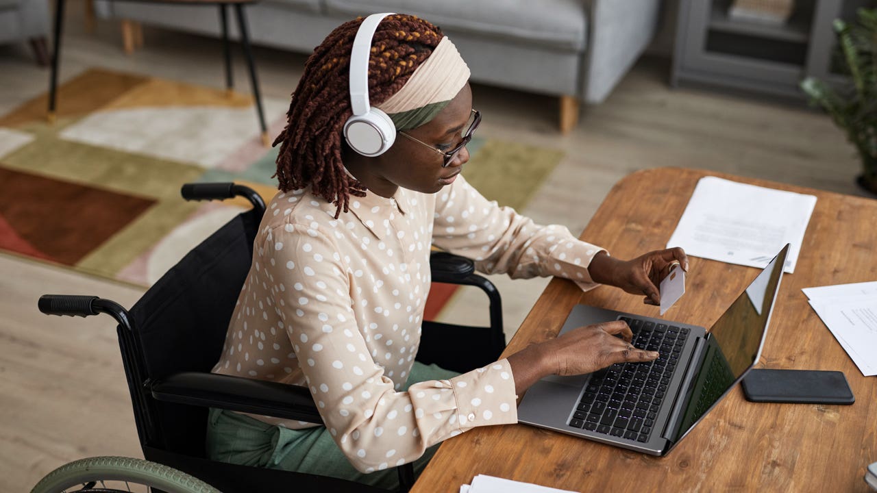 a person with headphone son working on a laptop