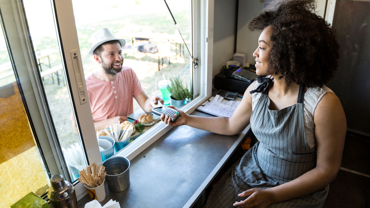 man paying for food with credit card at a food truck