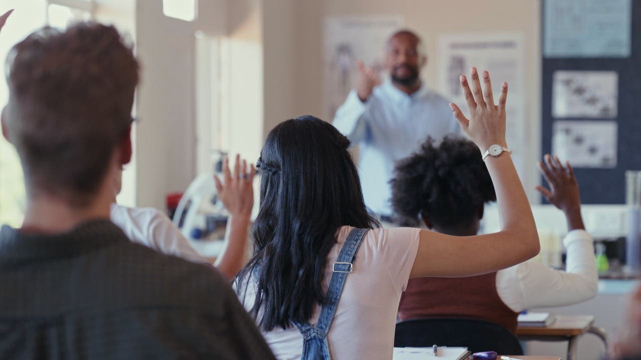 High school teacher calls on students in classroom