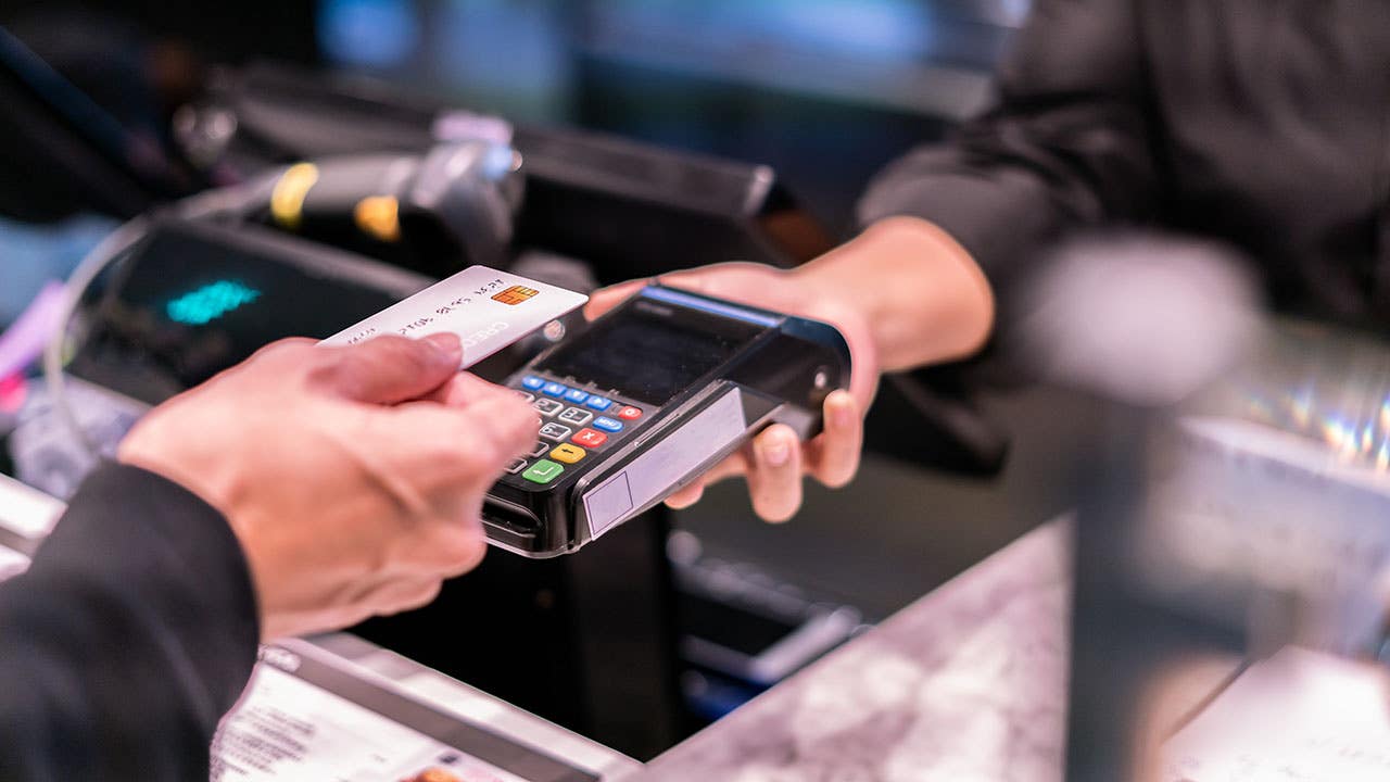 a person holding card next to card reader