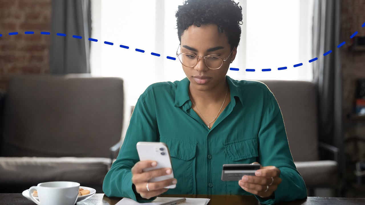 woman using smartphone with credit card in hand