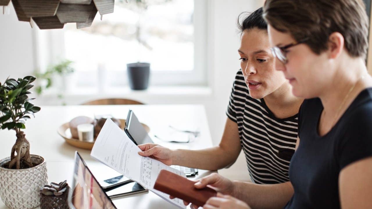 couple discussing over financial bills while using laptop at table