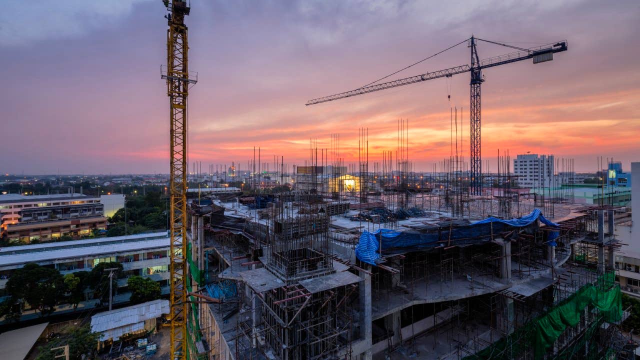 Twilight of a New Hospital Building being constructed with big crains