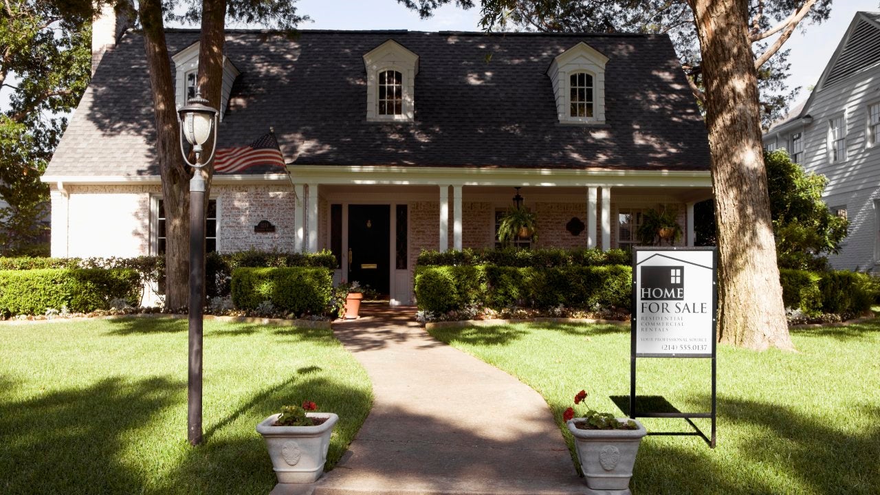 Exterior view of house with for sale sign, from front lawn