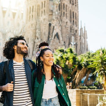 Smiling couple walking around Sagrada Familia church at Barcelona, Catalonia, Spain