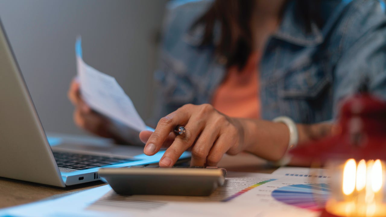 Close up of woman planning home budget and using calculator