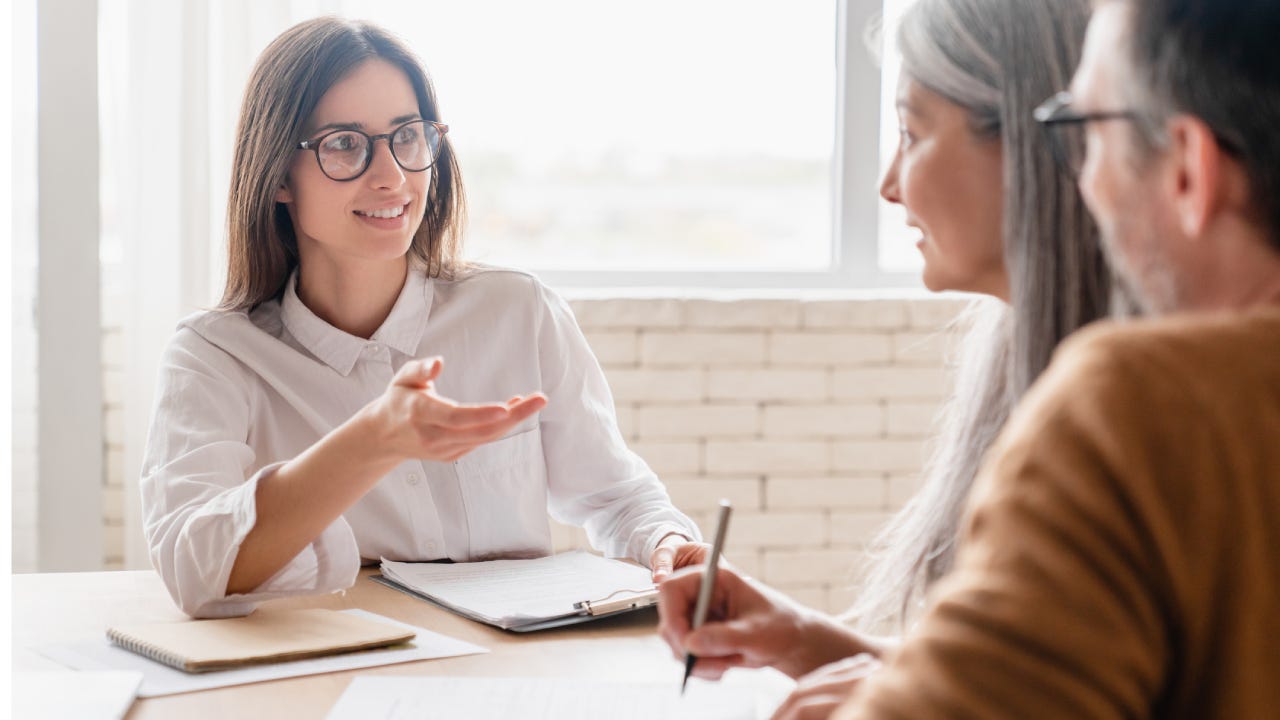 Young financial agent talking to an older couple