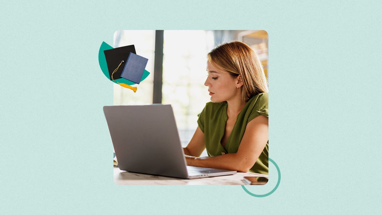A woman looks at a laptop.