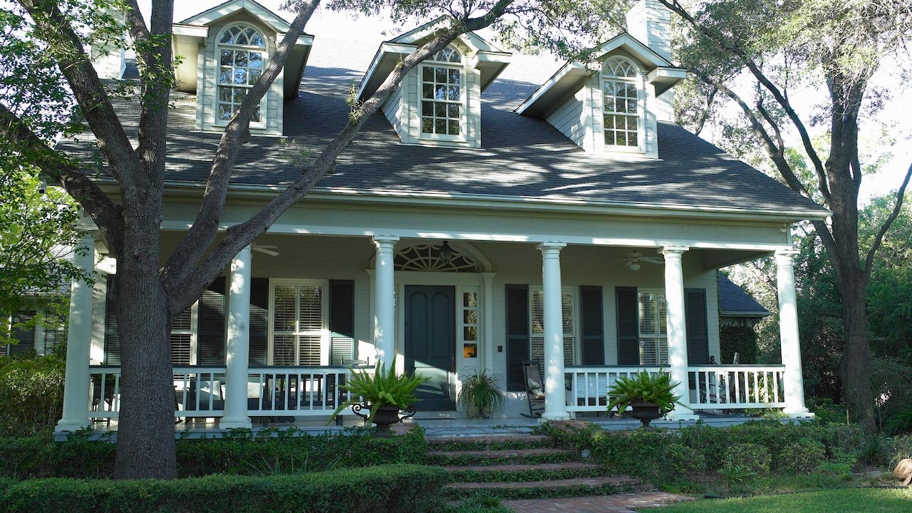 white house in san antonio texas with wide, columned front porch