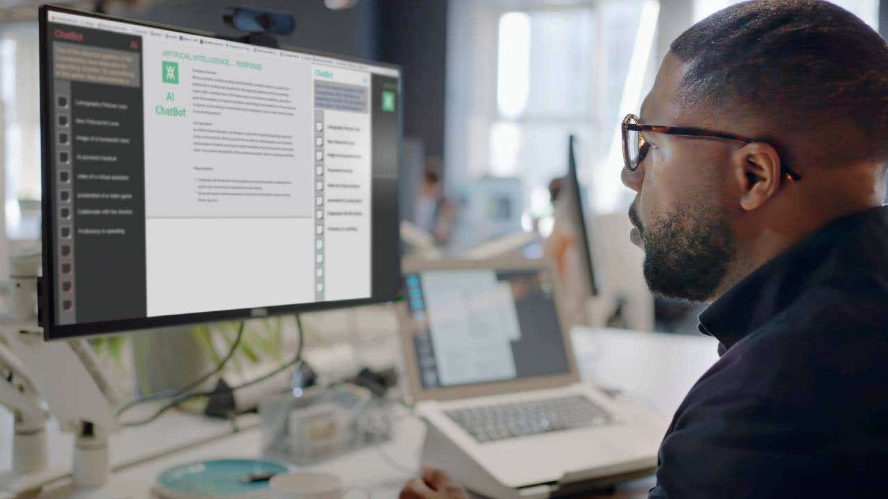 man’s face looking into a computer screen in an open plan working office
