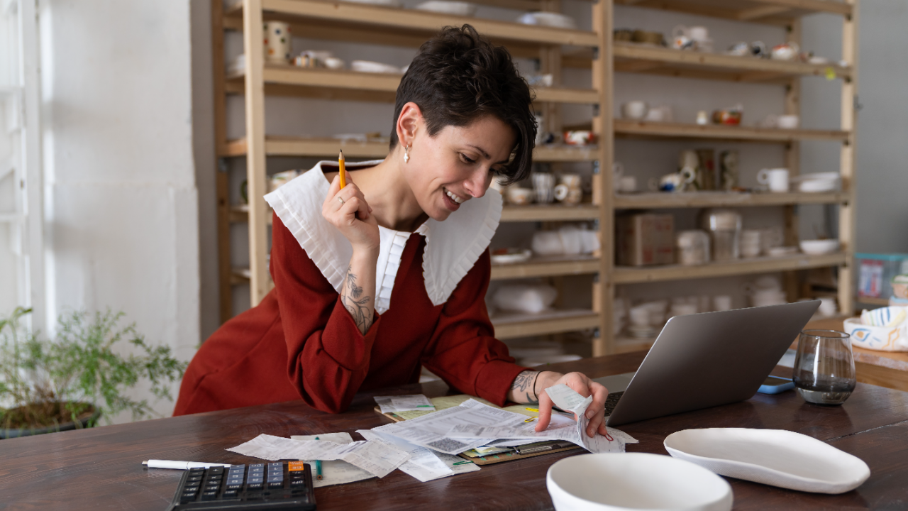 Woman calculates business revenue in her shop.