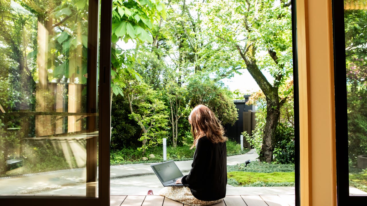 A woman working on a porch of a home