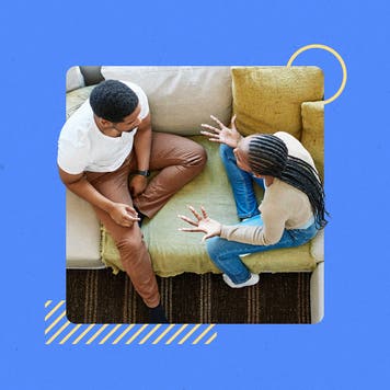 A couple sitting on a couch together, discussing an issue