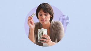 Woman putting money into a glass savings jar