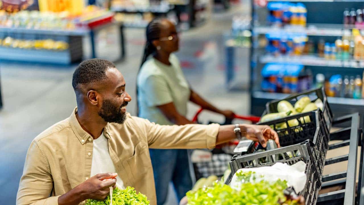 A man buying fresh vegetables while shopping at a supermarket.
