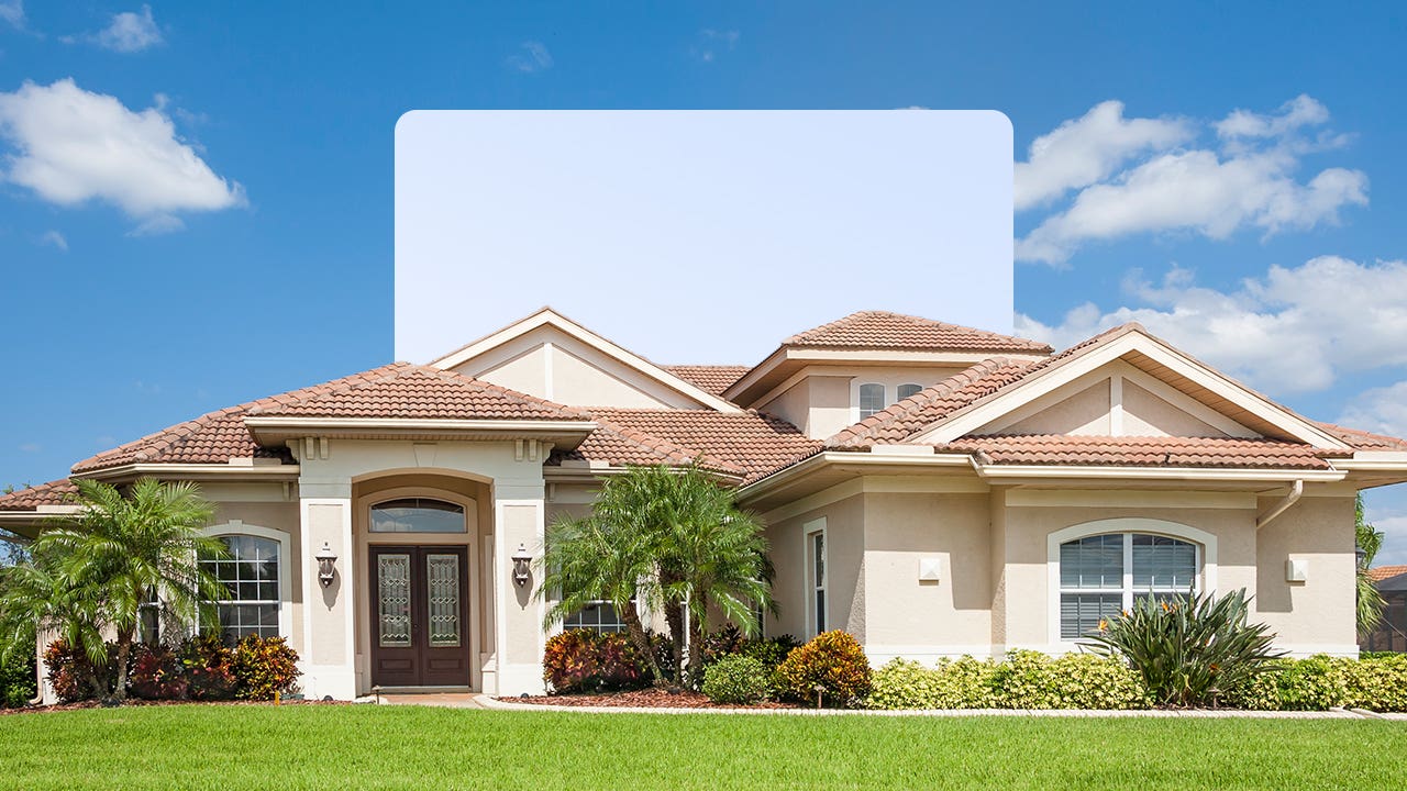 single family suburban home with green lawn and blue sky