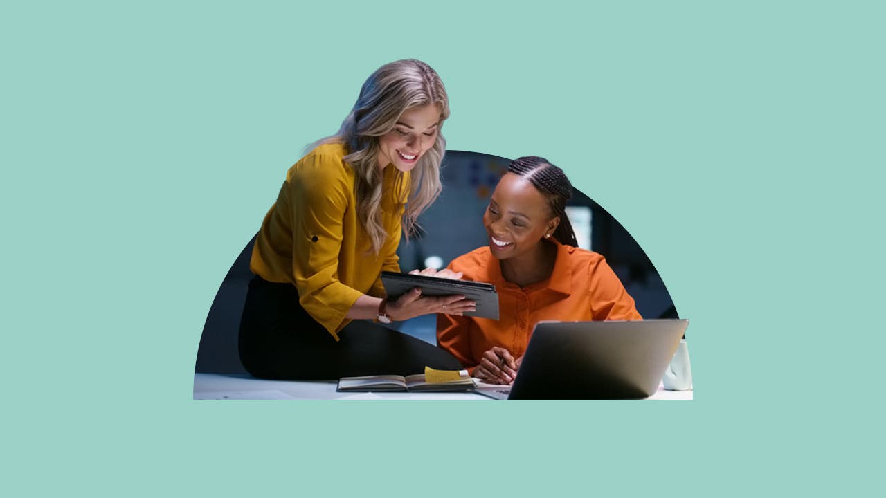 Two women look at an iPad.