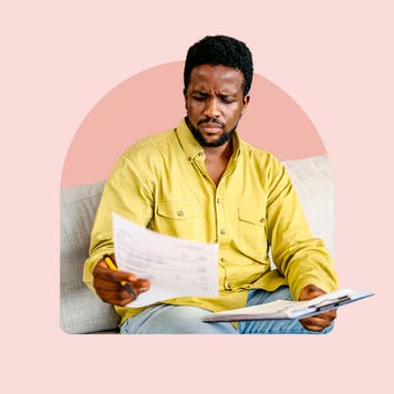 A black man looks at paperwork.