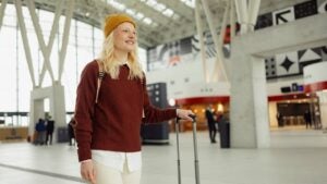 Young happy woman walking through airport.