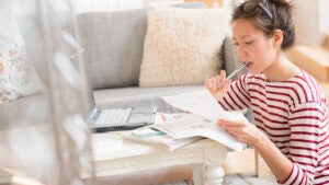 Woman paying bills on laptop.