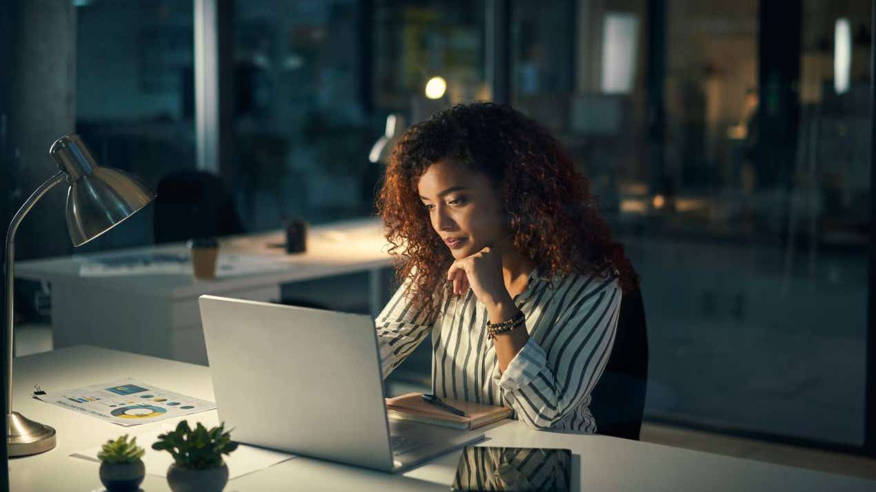 Shot of a young businesswoman using a laptop during a late night at work