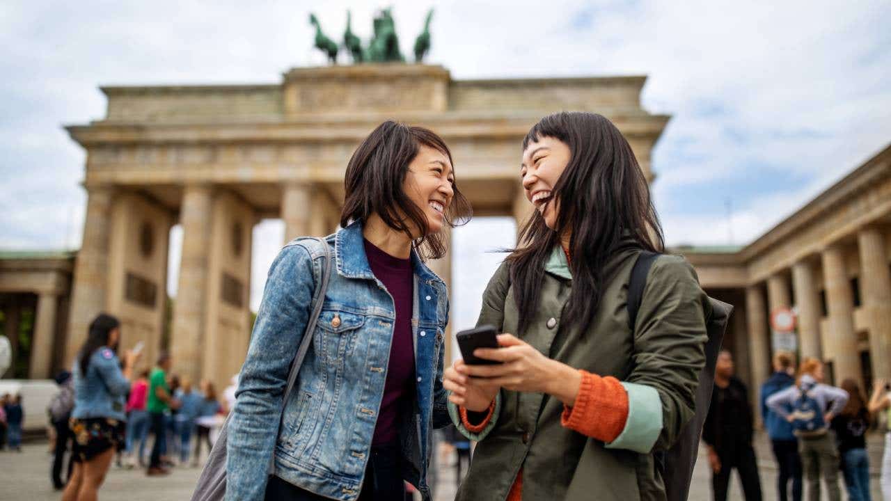 Cheerful friends standing against Brandenburg Gate
