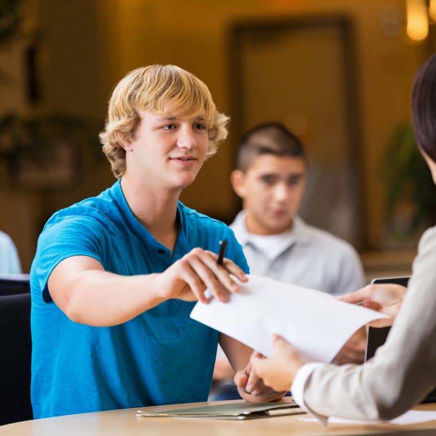 white male handing document to woman
