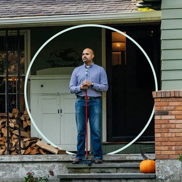 Person standing on front porch while holding a broom