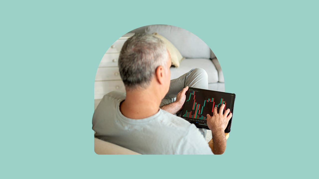 A man looks at a stock chart on his tablet.