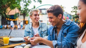 Group of friends eating outside and smiling