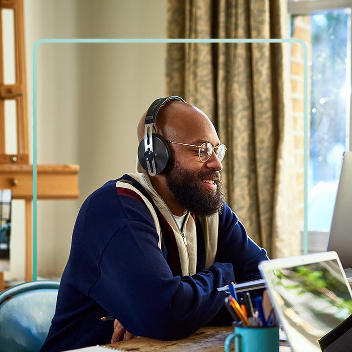 An older Black man studies on a laptop.